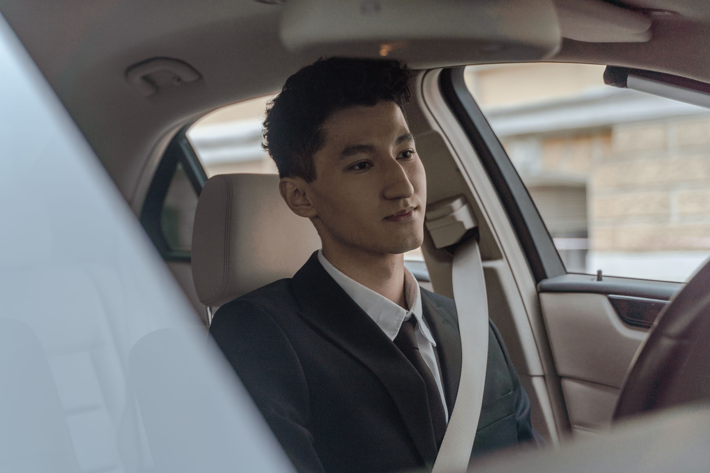 Professional driver in a suit inside a vehicle