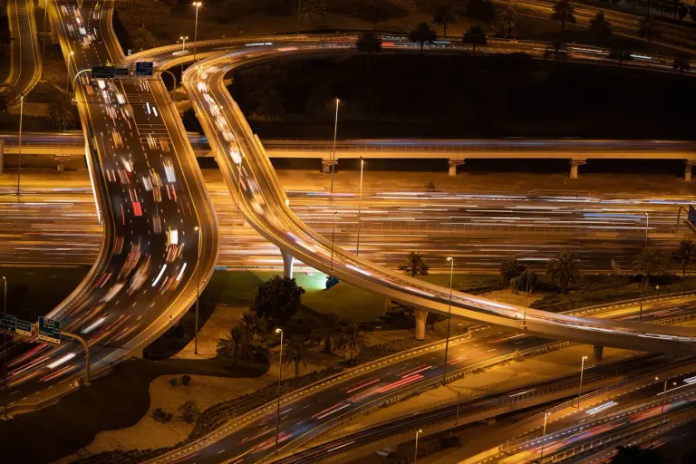 Curving city roads and vehicle traffic illuminated at night